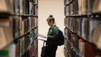 Student browsing library shelves
